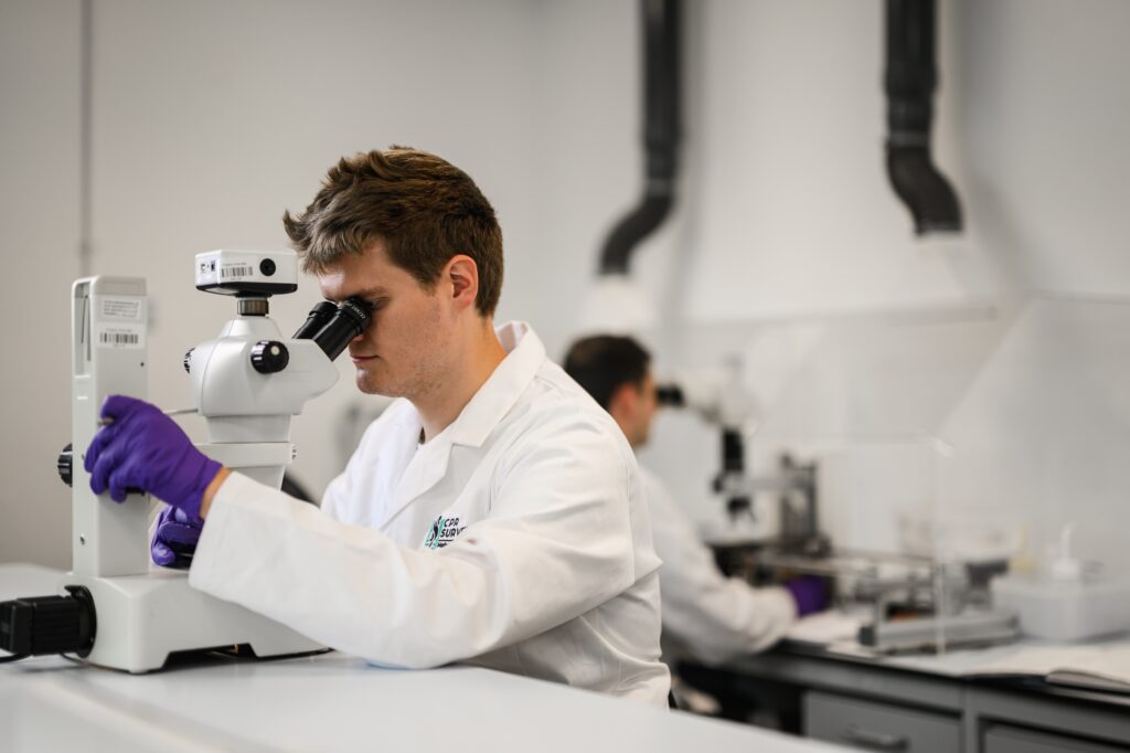 Researcher using a microscope in a lab coat Plankton Taxonomy Laboratory 