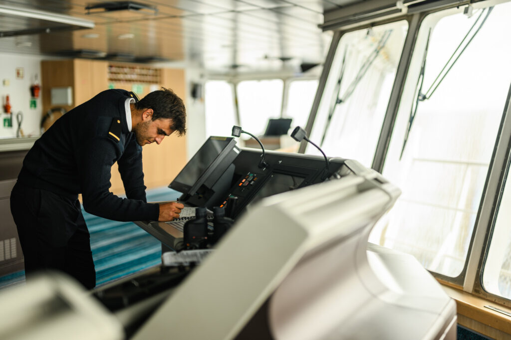 Ship Captain signing paperwork on the bridge of a vessel that tows a Continuous Plankton Recorder